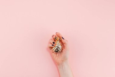 Yaratıcı en iyi görünüm düz siyah manikür küçük altın ananas pembe Kağıt arka plan üzerinde kopya alanı ile minimalizm tarzı tutan kadın kontrolden yatırın. Kadınsı blog, sosyal medya için şablon