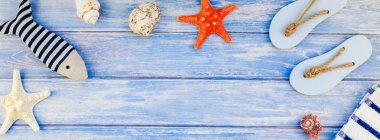 Uzun geniş afiş düz yaz seyahat tatil kavramı yatıyordu. Deniz ve deniz yıldızı pastel mavi ahşap plakalar ile arka plan kopya alanı rustik tarzı çerçeve şablonu metin üstten görünüm havlu Flip floplar