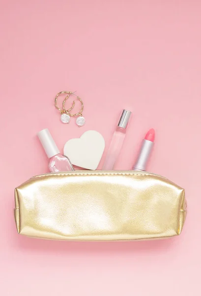 顶部看法平放置的金色女性钱包与化妆品耳环与复制空间千年粉红色纸背景最小的风格 女性博客社交媒体模板 — 图库照片