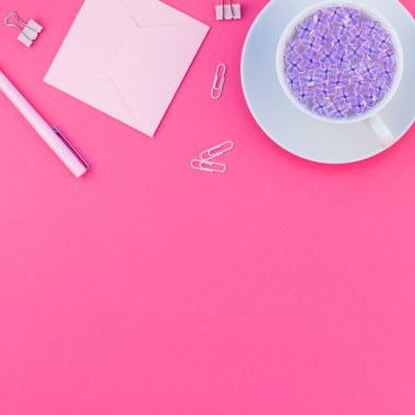 Üstten görünüm düz parlak pembe renk Kağıt arka plan en az stili üzerinde kopya alanı tasarım ofis malzemeleri tarz çalışma masası ve çay yatırın. Kadınsı blog sosyal medya için kare şablon
