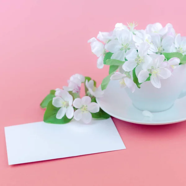 咖啡杯和白色苹果树绽放的花朵在粉红色的背景与明信片模拟和复制空间在最小的样式的创造性概念 模板文本 — 图库照片