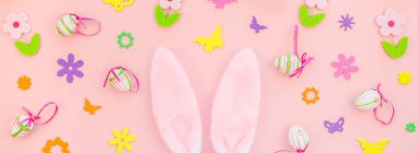 Yaratıcı Top View düzlük tatil kompozisyonu. Paskalya yumurtaları tavşan kulakları. Pembe kağıt arka plan üzerinde bahar çiçekleri.