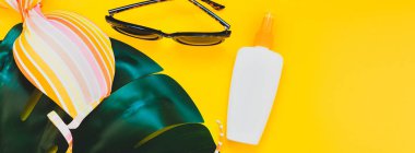 Tropikal orman palm monstera bırakır, güneş gözlüğü, Güneş kremi boş şişe mockup ve kadının mayo sarı Kağıt arka plan üzerinde. Yaz yaratıcı düz yatıyordu kavramı şablonu tatiller. Uzun geniş afiş