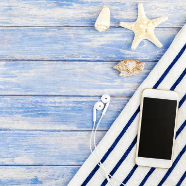 Kare yaratıcı düz yaz seyahat tatil kavramı yatıyordu. Plaj havlusu smartphone deniz kabuğu denizyıldızı üstten görünüm Kopyala yer mockup template metin için pastel mavi ahşap plakalar zemin üzerine
