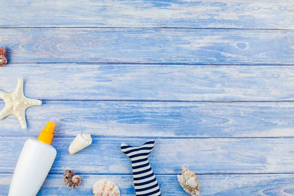 Yaratıcı düz kavramı yaz seyahat tatil yatıyordu. Pastel mavi ahşap plakalar arka plan kopya alanı rustik tarzı, çerçeve şablonu metin üzerinde güneş kremi şişe mockup kabukları ve denizyıldızı üstten görünüm