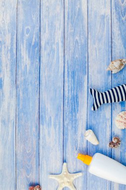Yaratıcı düz kavramı yaz seyahat tatil yatıyordu. Pastel mavi ahşap plakalar arka plan kopya alanı rustik tarzı, çerçeve şablonu metin üzerinde güneş kremi şişe mockup kabukları ve denizyıldızı üstten görünüm