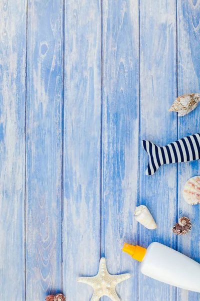Yaratıcı düz kavramı yaz seyahat tatil yatıyordu. Pastel mavi ahşap plakalar arka plan kopya alanı rustik tarzı, çerçeve şablonu metin üzerinde güneş kremi şişe mockup kabukları ve denizyıldızı üstten görünüm