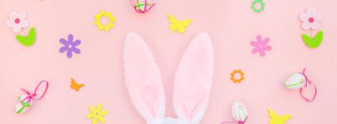 Yaratıcı Top View düzlük tatil kompozisyonu. Paskalya yumurtaları tavşan kulakları. Pembe kağıt arka plan üzerinde bahar çiçekleri.