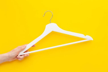 Yaratıcı en iyi görünüm düz yatıyordu Beyaz ahşap askı izole kalın sarı arka plan kopya alan minimalizm tarzı ile. Şablon moda kadınsı blog sosyal medya satış mağaza promosyon tasarım alışveriş konsepti