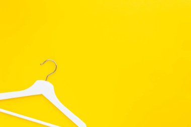 Yaratıcı en iyi görünüm düz yatıyordu Beyaz ahşap askı izole kalın sarı arka plan kopya alan minimalizm tarzı ile. Şablon moda kadınsı blog sosyal medya satış mağaza promosyon tasarım alışveriş konsepti