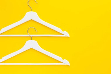 Yaratıcı en iyi görünüm düz yatıyordu Beyaz ahşap askı izole kalın sarı arka plan kopya alan minimalizm tarzı ile. Şablon moda kadınsı blog sosyal medya satış mağaza promosyon tasarım alışveriş konsepti
