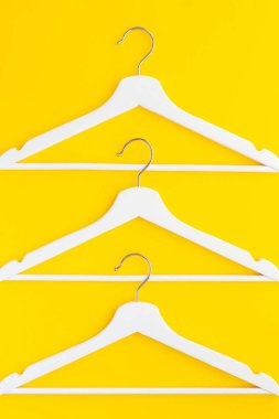 Yaratıcı en iyi görünüm düz yatıyordu Beyaz ahşap askı izole kalın sarı arka plan kopya alan minimalizm tarzı ile. Şablon moda kadınsı blog sosyal medya satış mağaza promosyon tasarım alışveriş konsepti