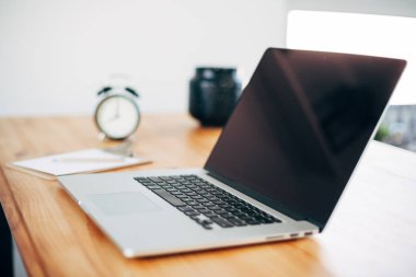 Rahat çalışma yerde ahşap masa ve modern dizüstü üzerinde döşeme ev ofis. Serbest çalışma kavramı