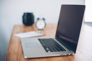 Rahat çalışma yerde ahşap masa ve modern dizüstü üzerinde döşeme ev ofis. Serbest çalışma kavramı