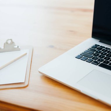 Rahat çalışma yerde ahşap masa ve modern dizüstü üzerinde döşeme ev ofis. Serbest iş kare kavramı