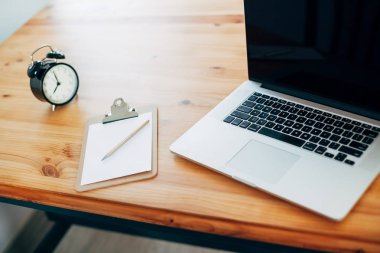 Rahat çalışma yerde ahşap masa ve modern dizüstü üzerinde döşeme ev ofis. Serbest çalışma kavramı