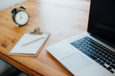 Rahat çalışma yerde ahşap masa ve modern dizüstü üzerinde döşeme ev ofis. Serbest çalışma kavramı