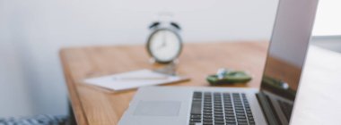 Rahat çalışma yerde ahşap masa ve modern dizüstü üzerinde döşeme ev ofis. Serbest çalışma kavramı. Uzun geniş afiş