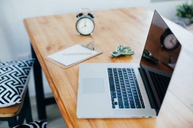 Rahat çalışma yerde ahşap masa ve modern dizüstü üzerinde döşeme ev ofis. Serbest çalışma kavramı