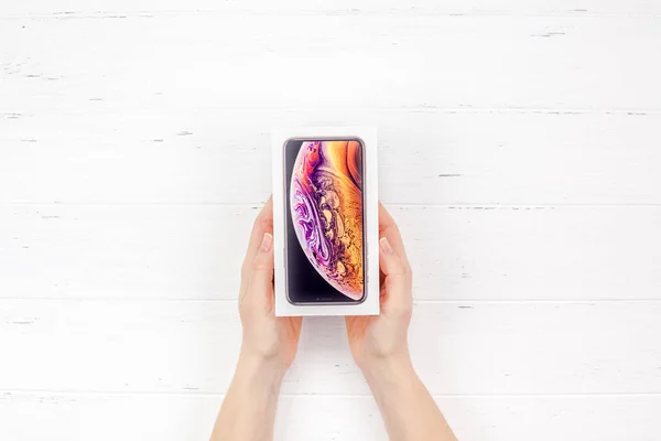 ベルリン ドイツ 2018 女性の手が白い木製の背景に対してアップル Iphone の最新スマート フォンのカラフルなボックスを保持します コピー スペースとボックス化解除の概念 — ストック写真