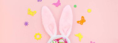 Yaratıcı Top View düzlük tatil kompozisyonu. Paskalya yumurtaları tavşan kulakları. Pembe kağıt arka plan üzerinde bahar çiçekleri.