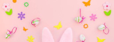 Yaratıcı Top View düzlük tatil kompozisyonu. Paskalya yumurtaları tavşan kulakları. Pembe kağıt arka plan üzerinde bahar çiçekleri.