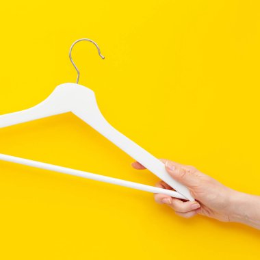 Yaratıcı en iyi görünüm düz yatıyordu Beyaz ahşap askı izole kalın sarı arka plan kopya alan minimalizm tarzı ile. Şablon moda kadınsı blog sosyal medya satış mağaza promosyon tasarım alışveriş konsepti
