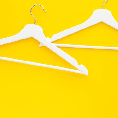Yaratıcı en iyi görünüm düz yatıyordu Beyaz ahşap askı izole kalın sarı arka plan kopya alan minimalizm tarzı ile. Şablon moda kadınsı blog sosyal medya satış mağaza promosyon tasarım alışveriş konsepti