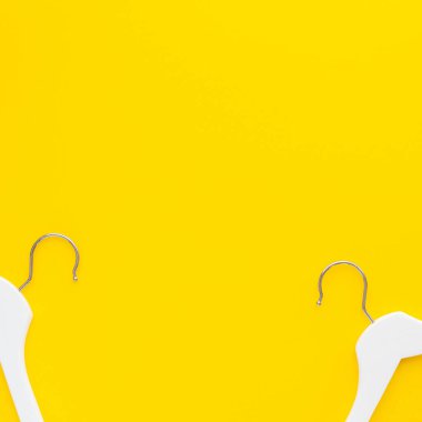 Yaratıcı en iyi görünüm düz yatıyordu Beyaz ahşap askı izole kalın sarı arka plan kopya alan minimalizm tarzı ile. Şablon moda kadınsı blog sosyal medya satış mağaza promosyon tasarım alışveriş konsepti