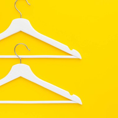 Yaratıcı en iyi görünüm düz yatıyordu Beyaz ahşap askı izole kalın sarı arka plan kopya alan minimalizm tarzı ile. Şablon moda kadınsı blog sosyal medya satış mağaza promosyon tasarım alışveriş konsepti