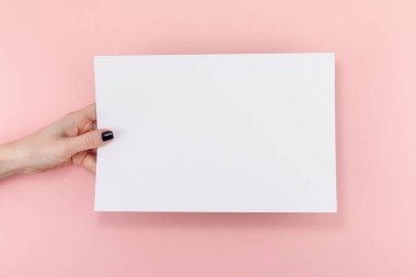 Yaratıcı düz üstten görünüm kadın el Siyah manikür boş A4 kağıt sayfa sahte ile pastel bin yıllık pembe Kağıt arka plan kopya alanı üzerinde yığmak. En az kavramı şablonu için bloglama yazı metin yazma