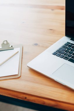 Rahat çalışma yerde ahşap masa ve modern dizüstü üzerinde döşeme ev ofis. Serbest çalışma kavramı