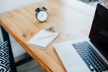 Rahat çalışma yerde ahşap masa ve modern dizüstü üzerinde döşeme ev ofis. Serbest çalışma kavramı