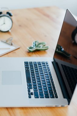 Rahat çalışma yerde ahşap masa ve modern dizüstü üzerinde döşeme ev ofis. Serbest çalışma kavramı