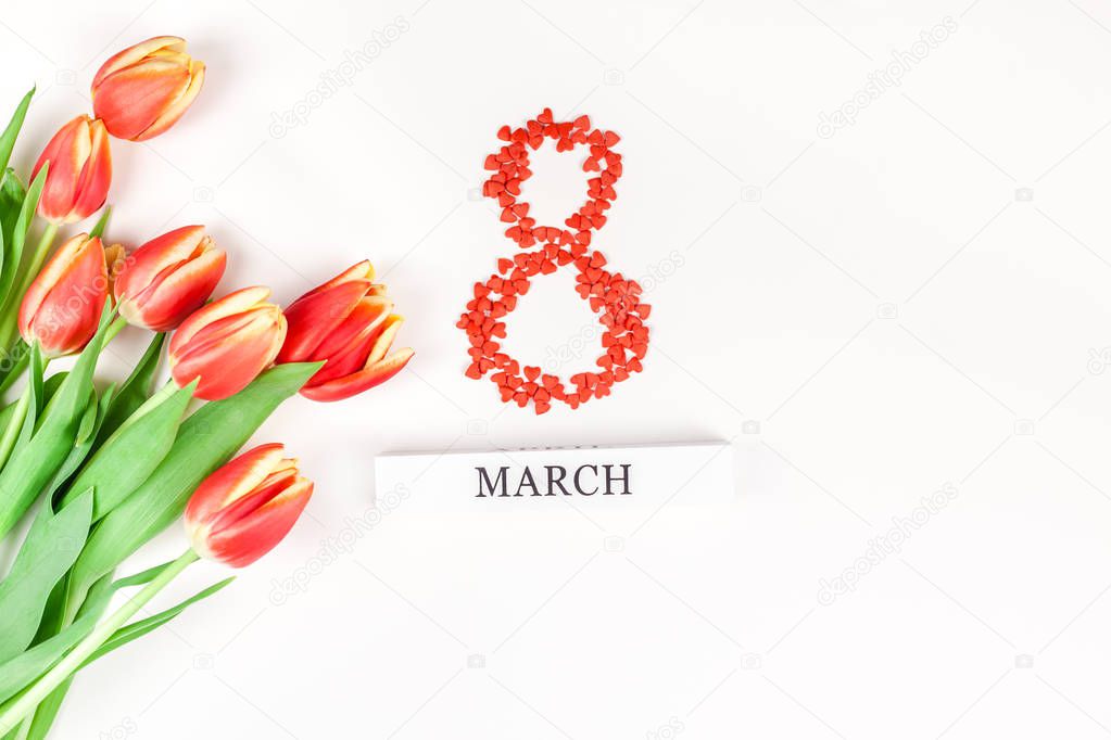 Creative flat lay top view 8 March International Women's Day greeting card with red tulips spring flowers on white background. Celebration Postcard template