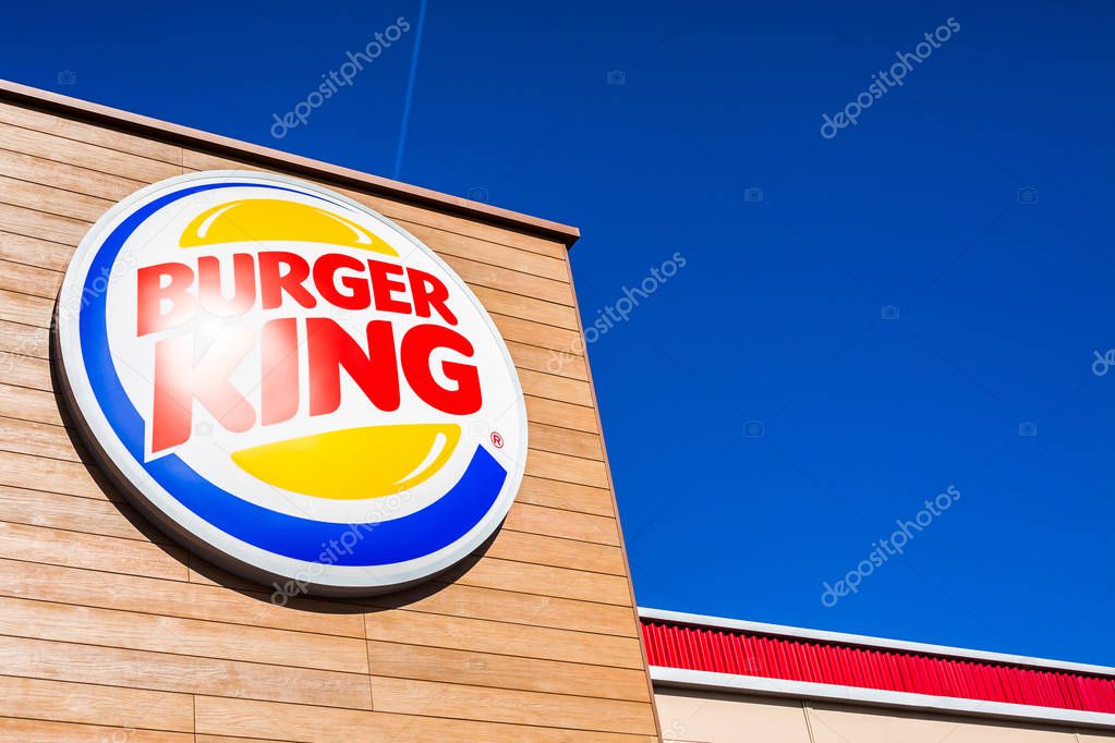 SAGUNTO, SPAIN - FEBRUARY 08, 2019: Burger King fast food restaurant logo at its building located in Sagunto shopping area, Spain. Clear bright blue sky
