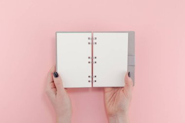 Yaratıcı düz bir bakış açısı olan kadın siyah manikürü boş defterle uzatıyordu. Milenyum Pembe Kağıt Fotokopi Alanı 'nda taklit ediliyordu. Metin harf blogları için asgari yazma konsept şablonu