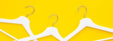 Yaratıcı en iyi görünüm düz yatıyordu Beyaz ahşap askı izole kalın sarı arka plan kopya alan minimalizm tarzı ile. Şablon moda kadınsı blog sosyal medya satış mağaza promosyon tasarım alışveriş konsepti