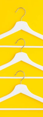 Yaratıcı en iyi görünüm düz yatıyordu Beyaz ahşap askı izole kalın sarı arka plan kopya alan minimalizm tarzı ile. Şablon moda kadınsı blog sosyal medya satış mağaza promosyon tasarım alışveriş konsepti