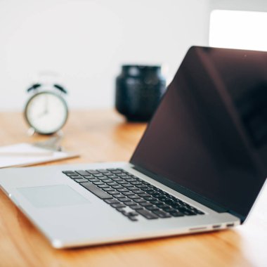 Rahat çalışma yerde ahşap masa ve modern dizüstü üzerinde döşeme ev ofis. Serbest iş kare kavramı