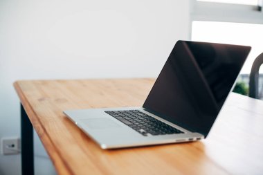 Rahat çalışma yerde ahşap masa ve modern dizüstü üzerinde döşeme ev ofis. Serbest çalışma kavramı