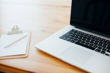 Rahat çalışma yerde ahşap masa ve modern dizüstü üzerinde döşeme ev ofis. Serbest çalışma kavramı