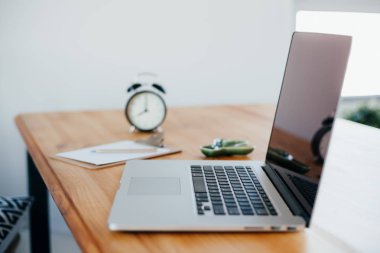 Rahat çalışma yerde ahşap masa ve modern dizüstü üzerinde döşeme ev ofis. Serbest çalışma kavramı