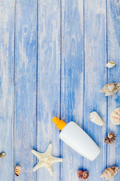 Yaratıcı düz kavramı yaz seyahat tatil yatıyordu. Pastel mavi ahşap plakalar arka plan kopya alanı rustik tarzı, çerçeve şablonu metin üzerinde güneş kremi şişe mockup kabukları ve denizyıldızı üstten görünüm