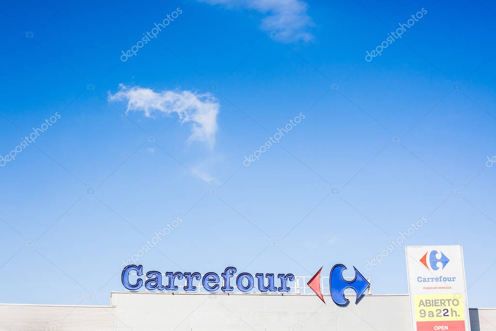 ORIHUELA, SPAIN - FEBRUARY 19, 2019: Carrefour supermarket chain brand logo at its building located in Orihuela shopping area, Spain. Clear bright blue sky