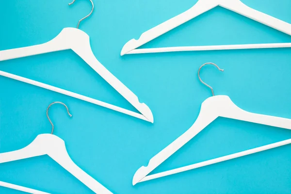 White wooden hangers on blue background — Stock Photo, Image