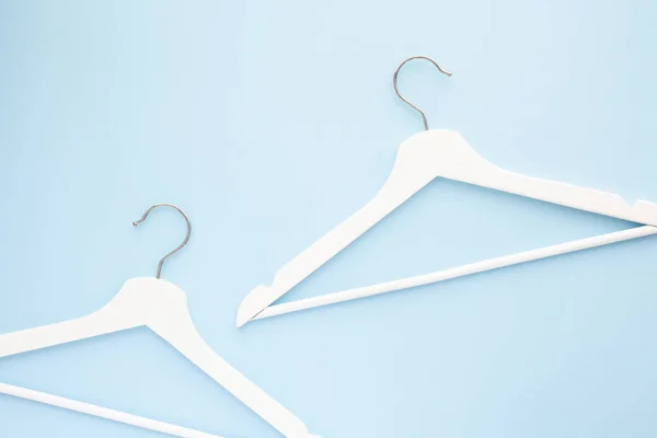 White wooden hangers on blue background — Stock Photo, Image