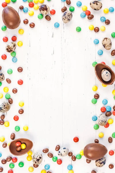 Moldura de Páscoa com ovos de chocolate, doces coloridos — Fotografia de Stock