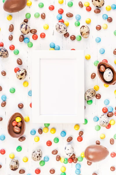 Moldura de Páscoa com ovos de chocolate, doces coloridos — Fotografia de Stock