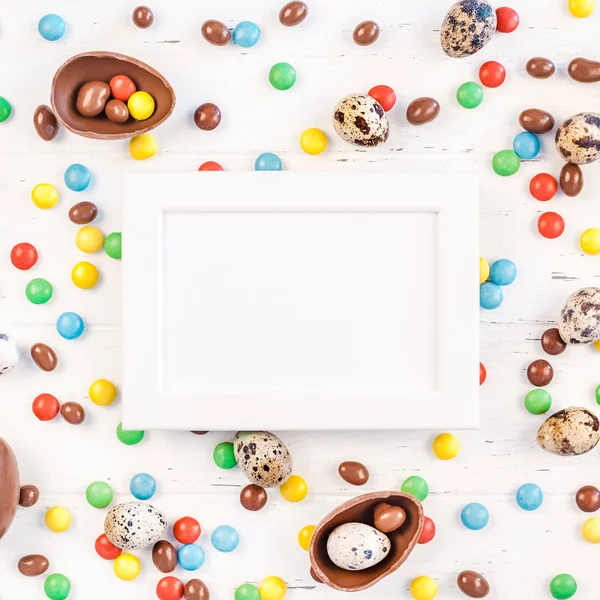 Easter frame with chocolate eggs, colorful candies